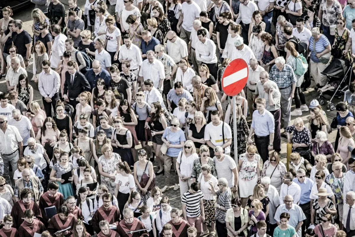 Crowd gathered around a red no-entry sign seen from above